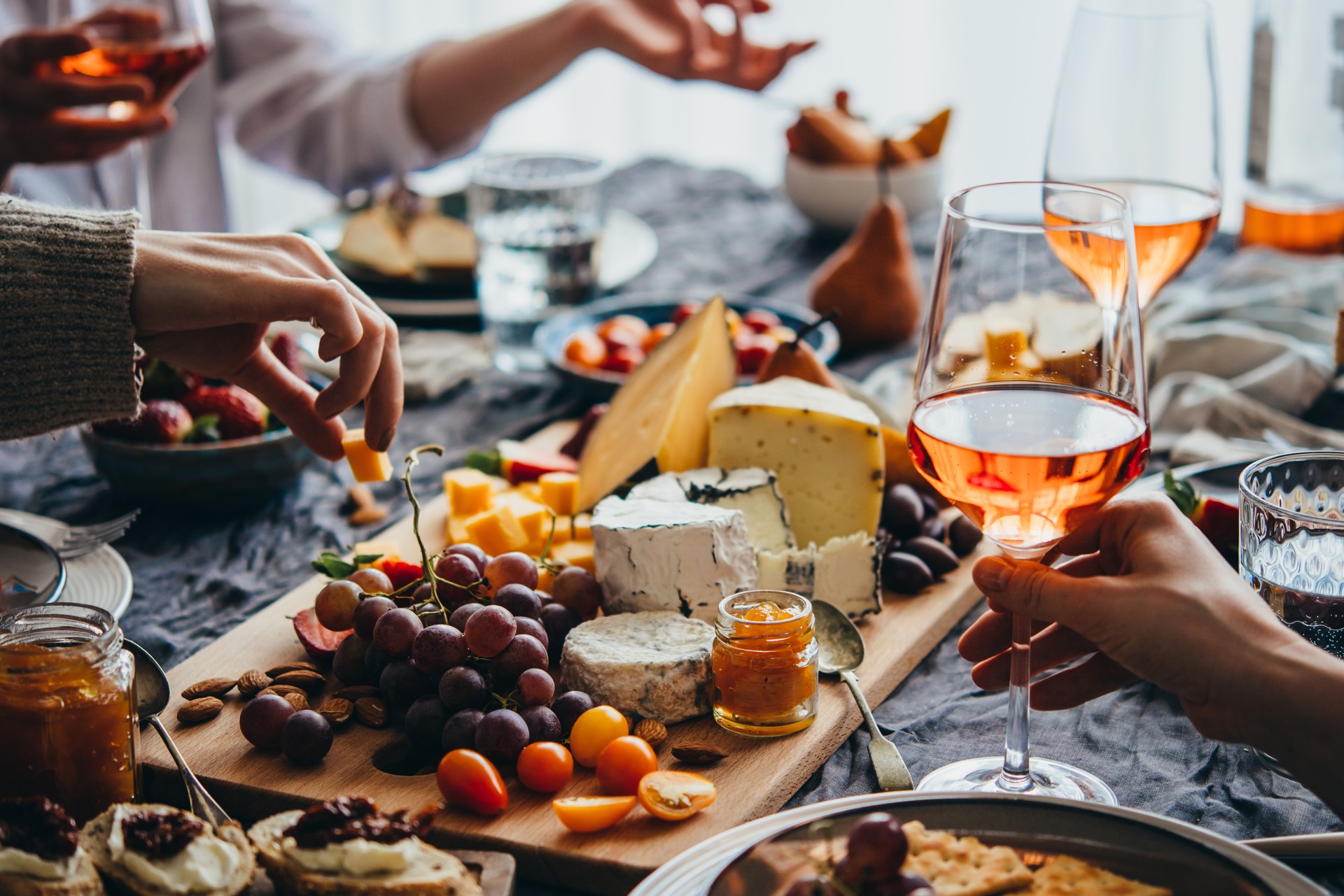Friends sharing a cheese board and rosé at a Parisian-inspired dinner table